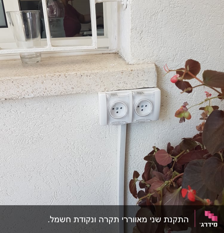 שקע חשמל כפול מותקן על קיר לבן